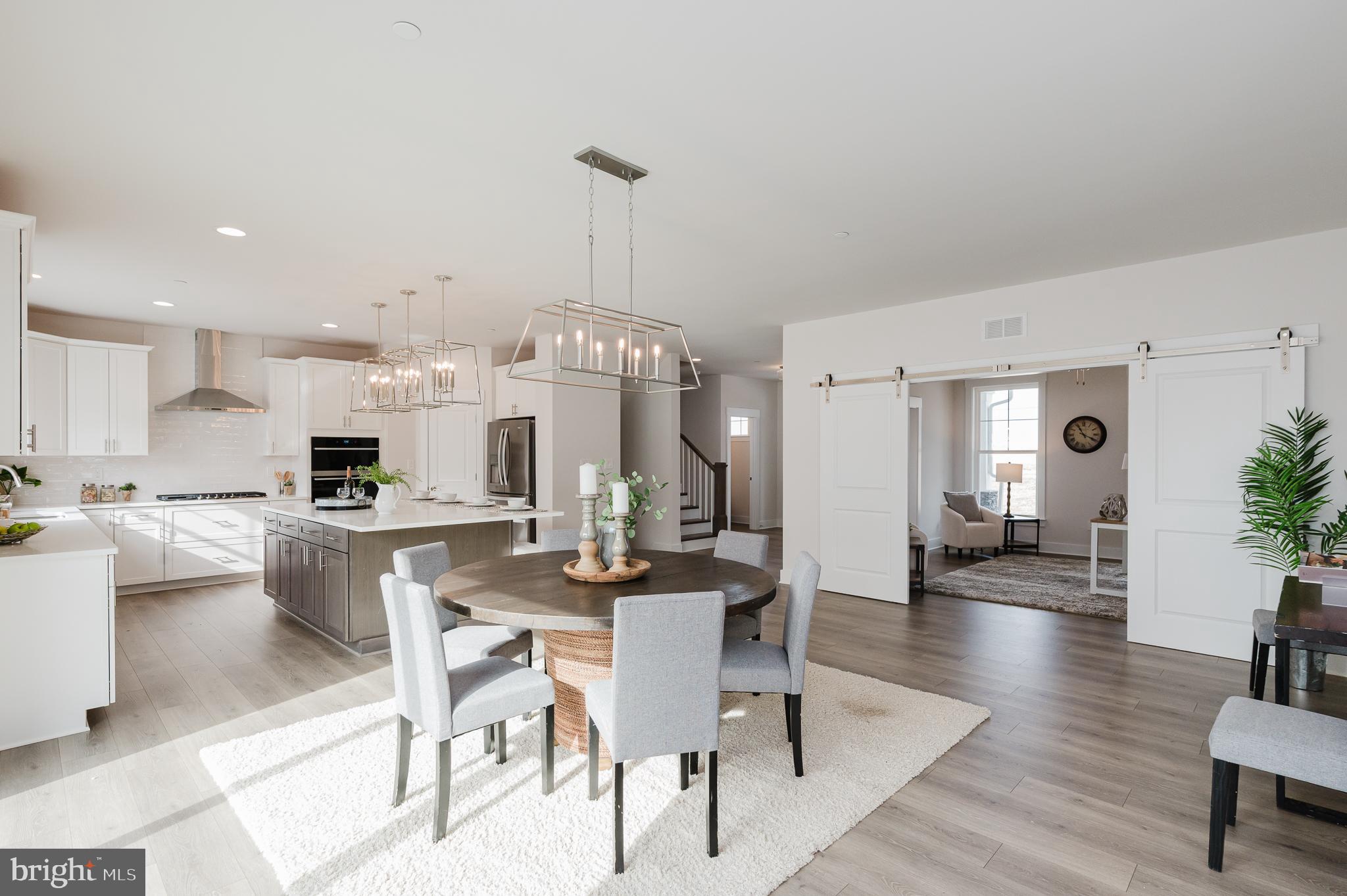 1605 A Oakland Road Freeland, MD 21053 - Photo 13 of 32 a kitchen with stainless steel appliances kitchen island granite countertop a dining table chairs and white cabinets