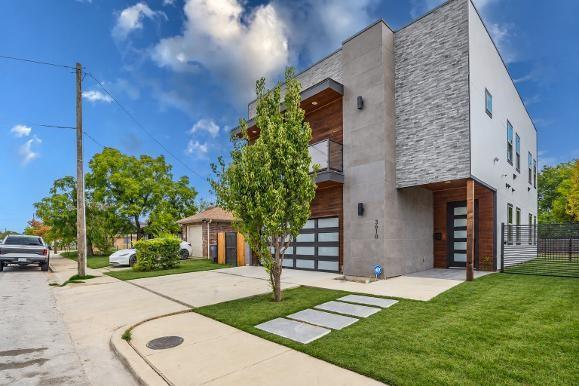3610 Vilbig Road Dallas, TX 75212 - Photo 25 of 29 Modern exterior featuring stacked stone, stucco, wood-finish siding, and a contemporary glass panel garage door