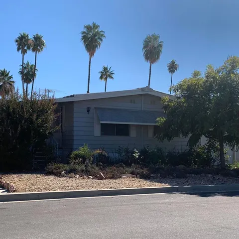 a front view of a house with a yard and potted plants