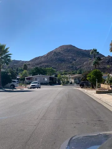 a room with stainless steel appliances kitchen island a table chairs and a wooden floor