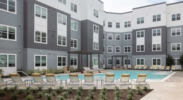 a view of a building with swimming tub and sitting chairs