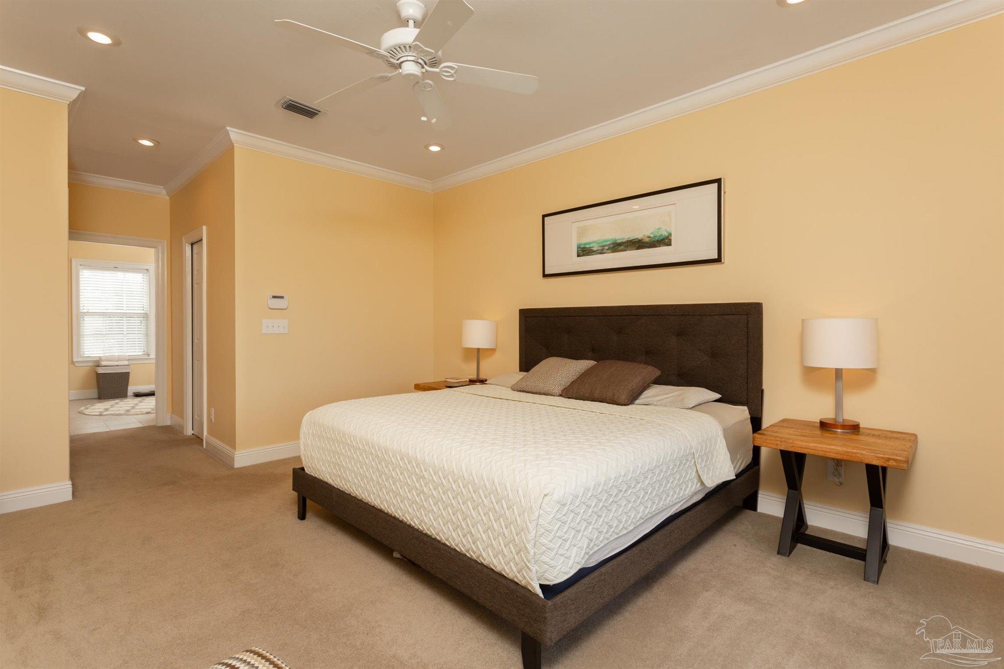 864 Sailfish Court Perdido Key, FL 32507 - Photo 19 of 40 a spacious bedroom with a bed and a lamp