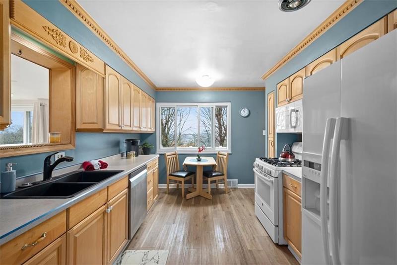 209 Cherokee Road Pittsburgh, PA 15241 - Photo 13 of 41 a kitchen with stainless steel appliances a stove a sink dishwasher a refrigerator and cabinets with wooden floor