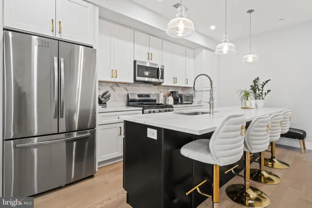 a kitchen with stainless steel appliances granite countertop a sink a stove and a wooden floors