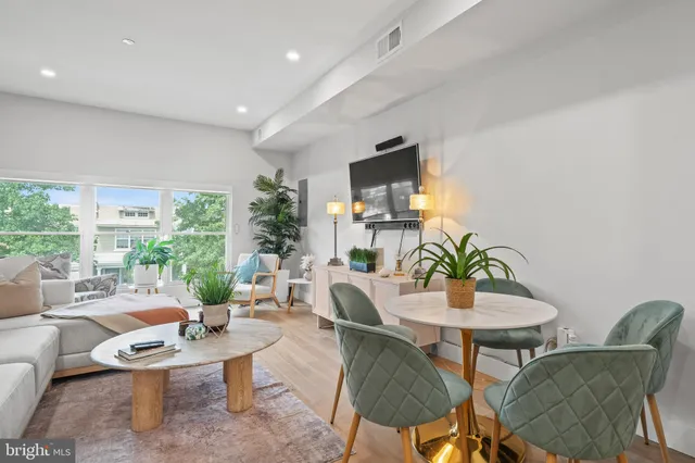 a living room with furniture a flat screen tv and a large window
