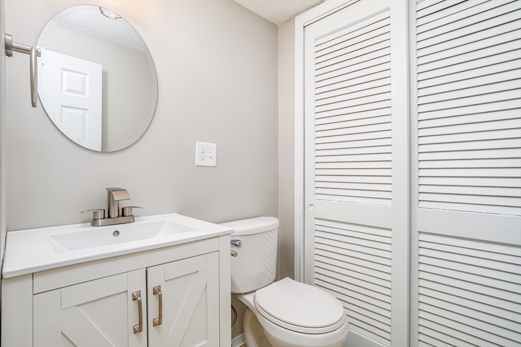 516 Ridgefield Circle, Unit C Clinton, MA 01510 - Photo 13 of 36 a bathroom with a sink a mirror a toilet and a window