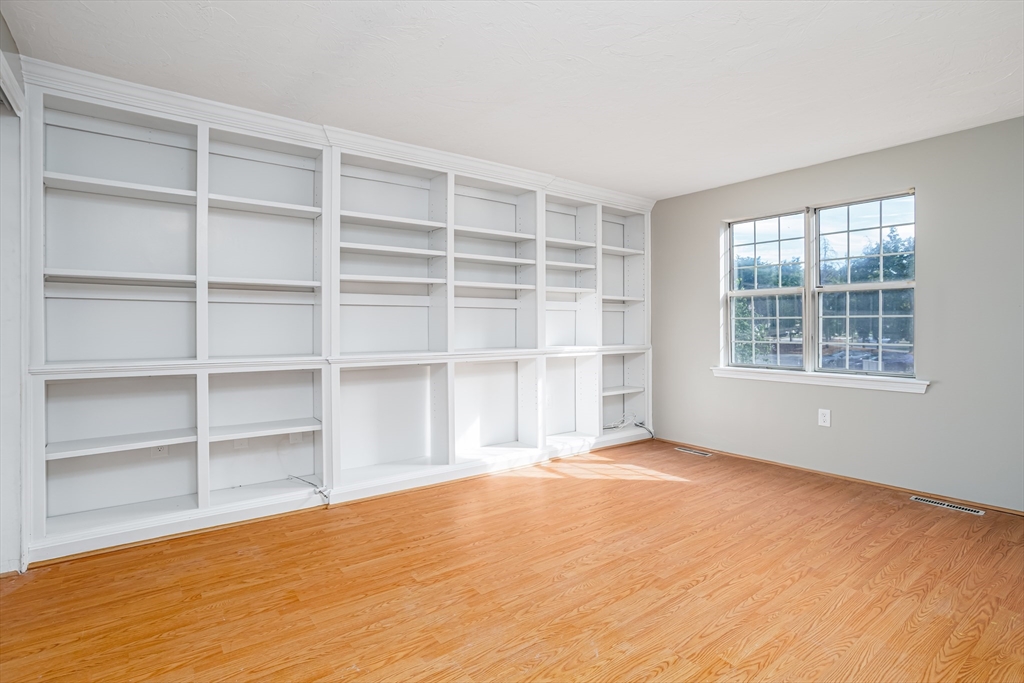 516 Ridgefield Circle, Unit C Clinton, MA 01510 - Photo 24 of 36 a view of an empty room with a window and wooden floor