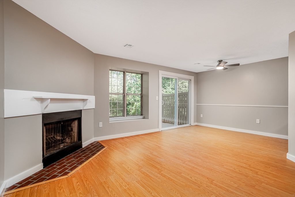 516 Ridgefield Circle, Unit C Clinton, MA 01510 - Photo 8 of 36 a view of an empty room with a fireplace and a window