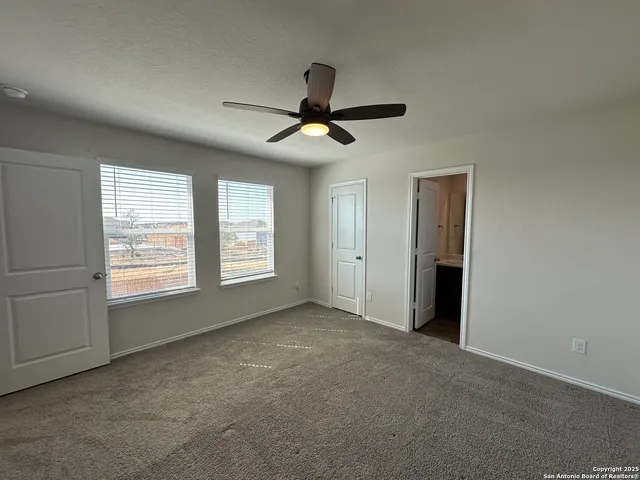 an empty room with closet and windows
