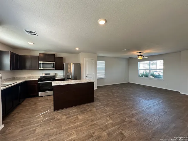 a large kitchen with stainless steel appliances granite countertop a large counter top and a stove top oven