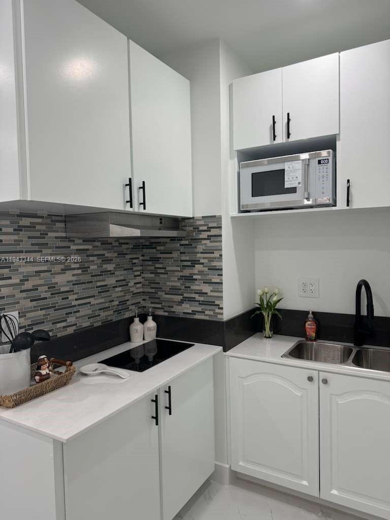 12970 Southwest 187th Street, Unit EFFICIENCY Miami, FL 33177 - Photo 17 of 30 a kitchen with a sink and cabinets