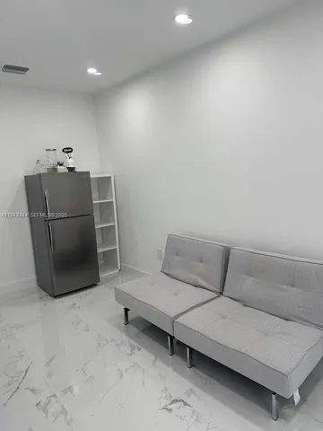 a room with a refrigerator and mirror