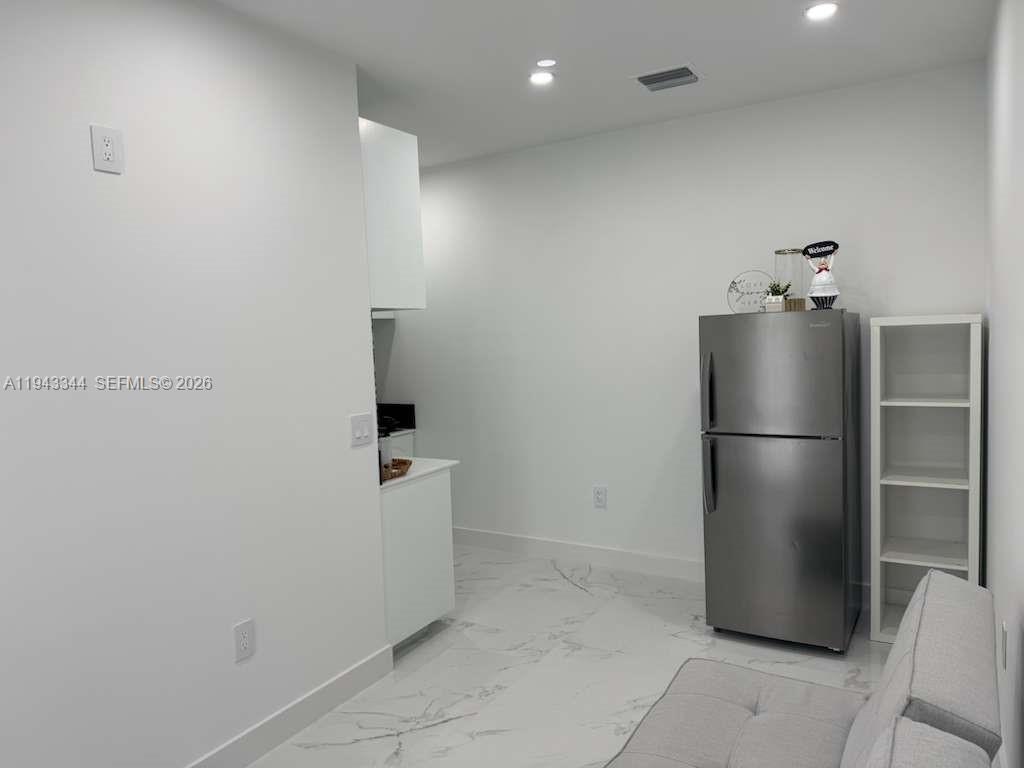 12970 Southwest 187th Street, Unit EFFICIENCY Miami, FL 33177 - Photo 21 of 30 a room with a refrigerator and mirror