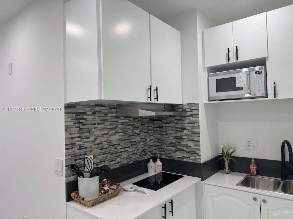 12970 Southwest 187th Street, Unit EFFICIENCY Miami, FL 33177 - Photo 22 of 30 a kitchen with cabinets and appliances