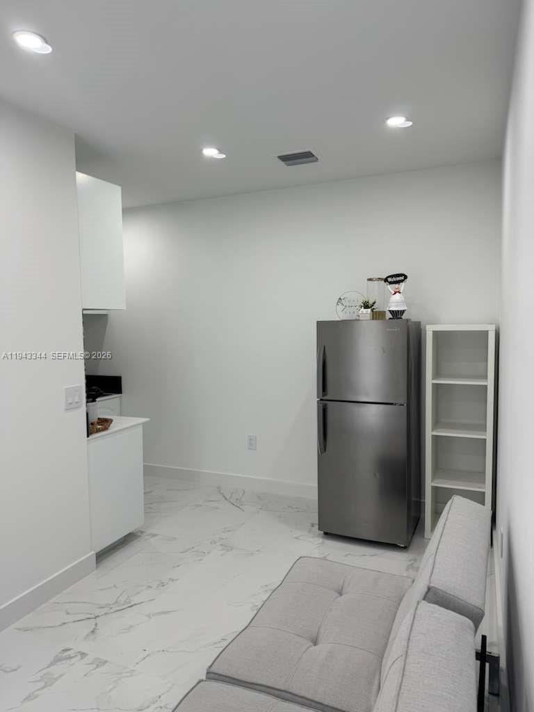 12970 Southwest 187th Street, Unit EFFICIENCY Miami, FL 33177 - Photo 25 of 30 a kitchen with stainless steel appliances a refrigerator and a stove top oven