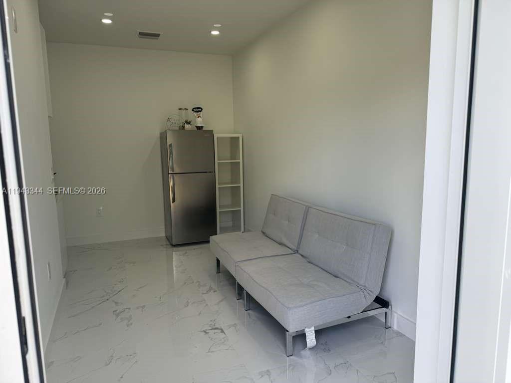 12970 Southwest 187th Street, Unit EFFICIENCY Miami, FL 33177 - Photo 27 of 30 a living room with furniture and a refrigerator