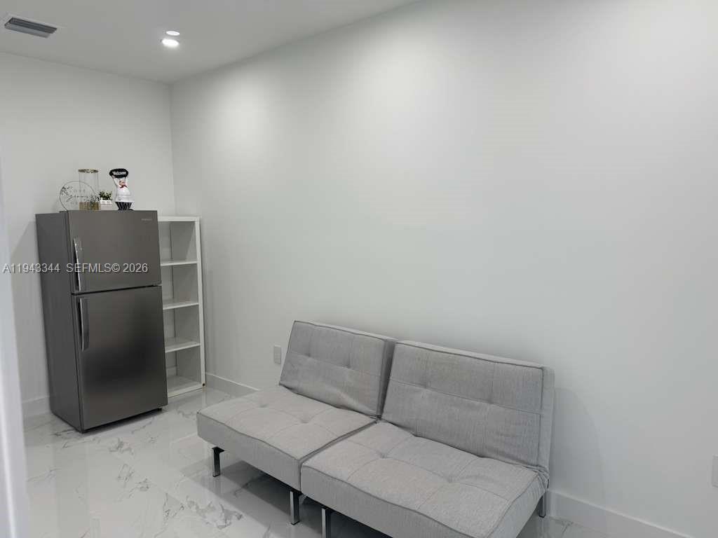 12970 Southwest 187th Street, Unit EFFICIENCY Miami, FL 33177 - Photo 29 of 30 a living room with furniture and a refrigerator