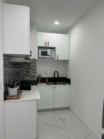 a kitchen with stainless steel appliances a sink stove and cabinets