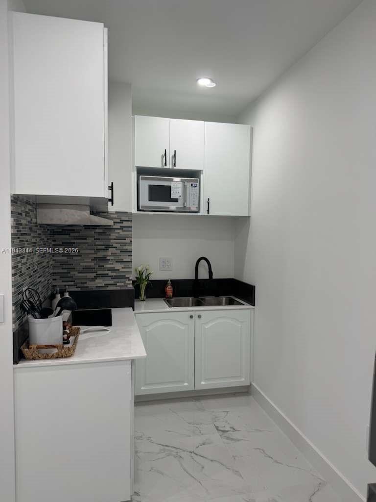 12970 Southwest 187th Street, Unit EFFICIENCY Miami, FL 33177 - Photo 9 of 30 a kitchen with stainless steel appliances a sink stove and cabinets