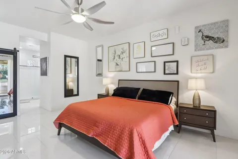 a large bedroom with a bed and wooden floor