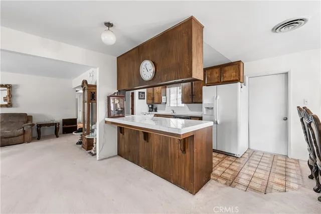 a kitchen with stainless steel appliances granite countertop a sink and a refrigerator