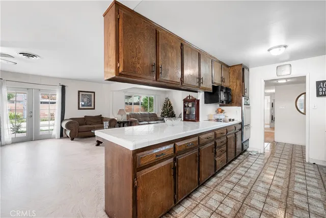 a kitchen with stainless steel appliances a sink dishwasher stove refrigerator and cabinets