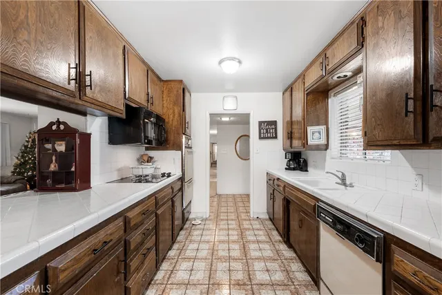 a large kitchen with stainless steel appliances granite countertop a sink stove and refrigerator