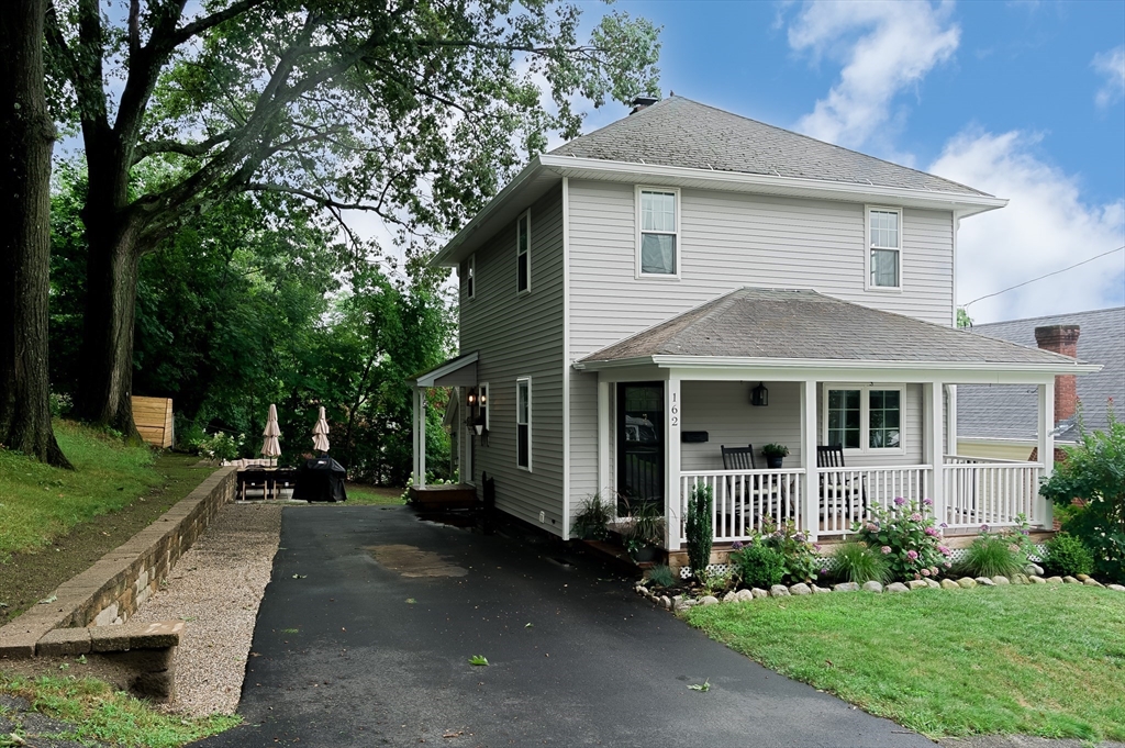 a front view of a house with a yard and trees
