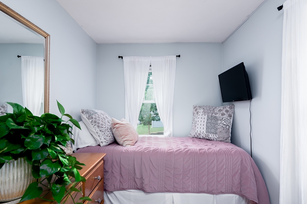 162 King Philip Road Worcester, MA 01606 - Photo 17 of 26 a bedroom with a bed tv and a potted plant