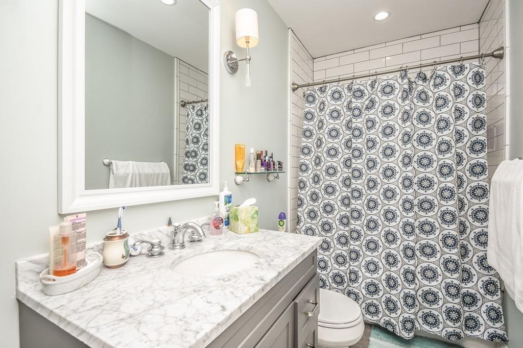 6 Edgehill Road Billerica, MA 01862 - Photo 21 of 24 a bathroom with a granite countertop sink a toilet and a shower curtain