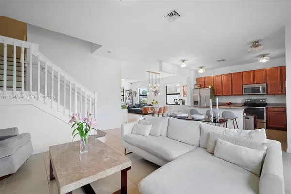 a living room with furniture kitchen view and a potted plant