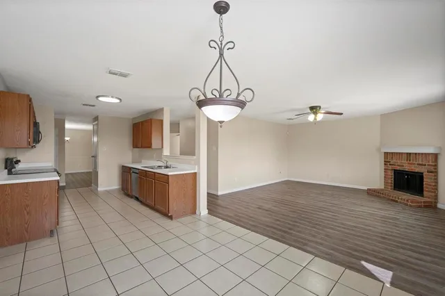 a view of kitchen with sink refrigerator and cabinets