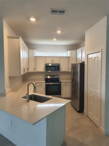 a kitchen with refrigerator and cabinets