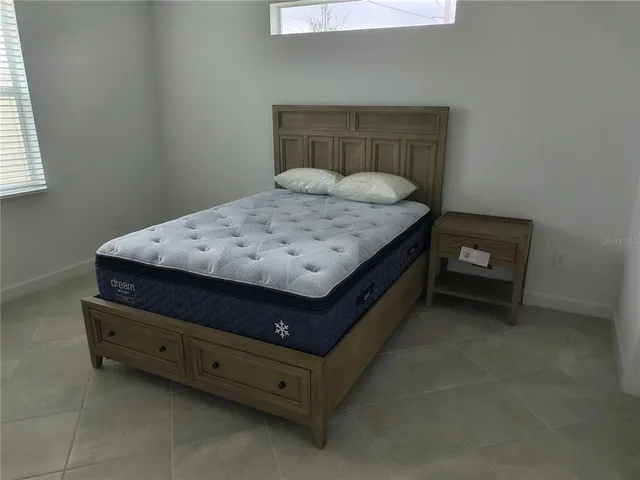 a bed sitting in a room next to a window