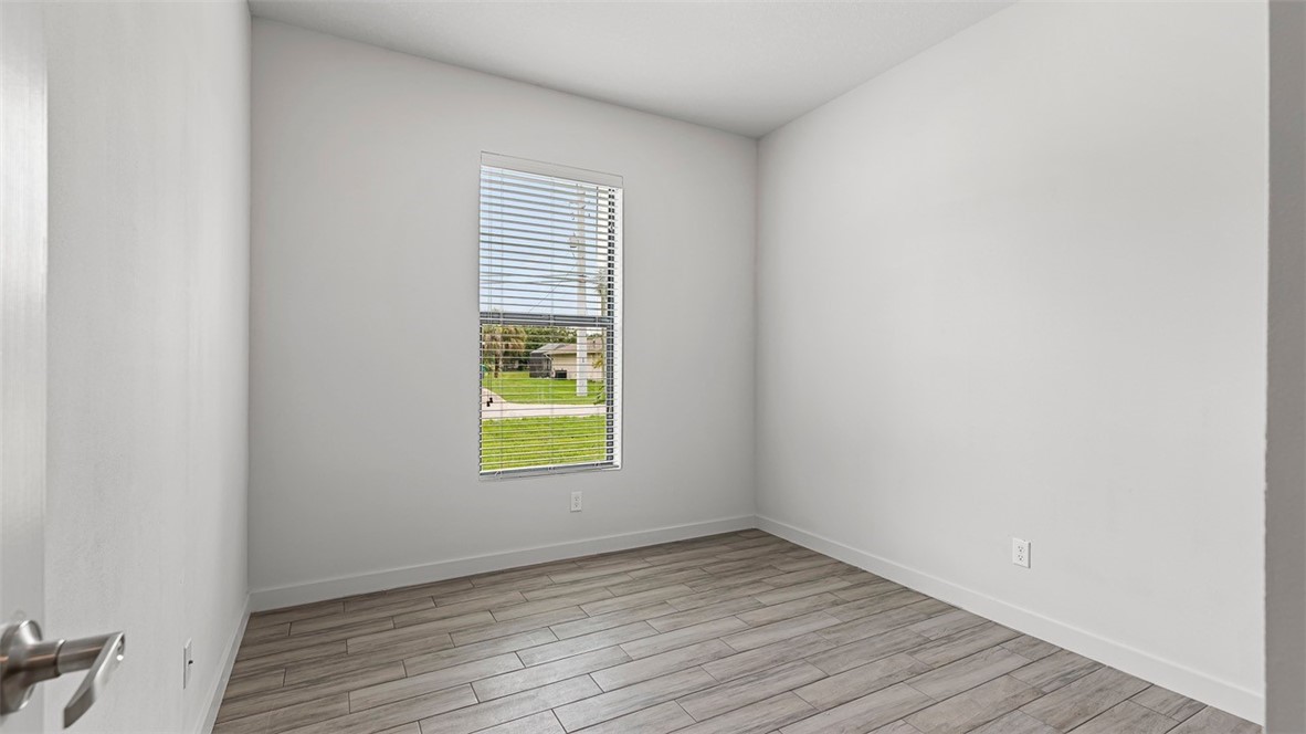 7008 Eden Road Fort Pierce, FL 34951 - Photo 15 of 29 a view of an empty room with wooden floor and a window