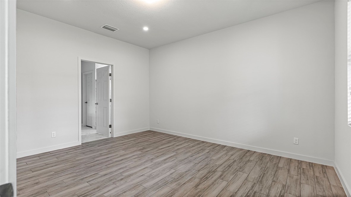 7008 Eden Road Fort Pierce, FL 34951 - Photo 18 of 29 a view of room with wooden floor and white walls