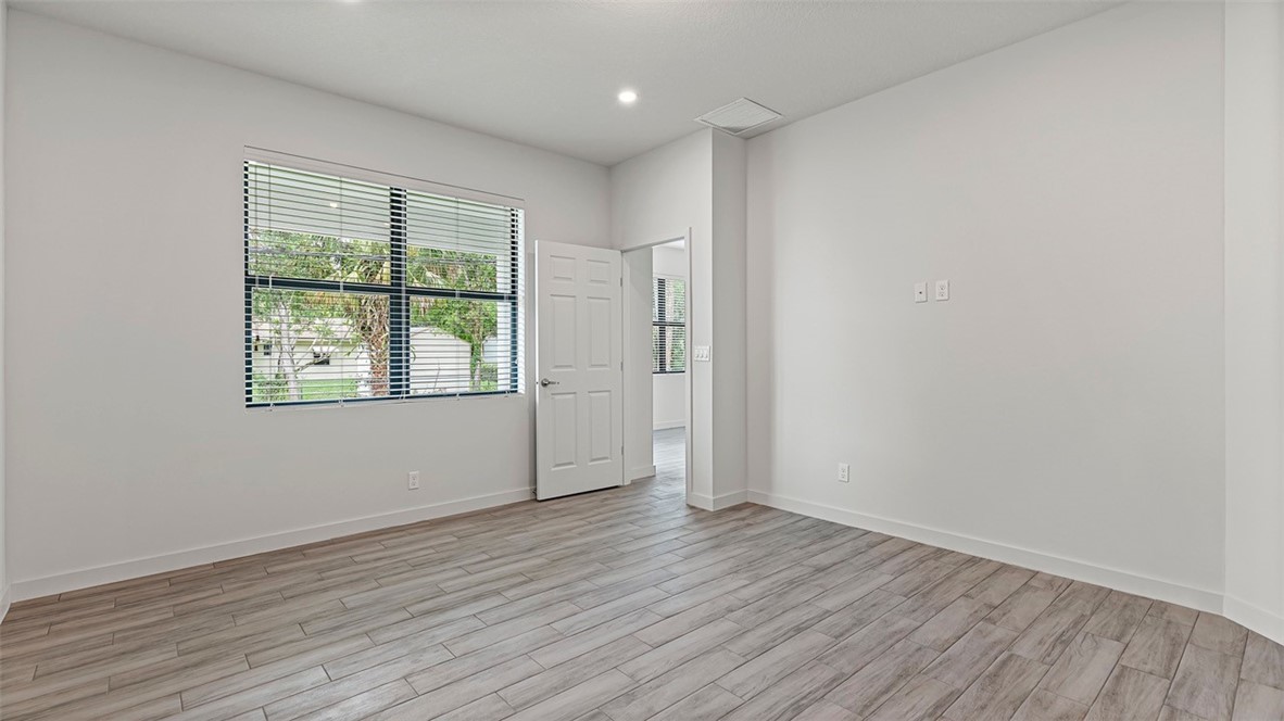 7008 Eden Road Fort Pierce, FL 34951 - Photo 19 of 29 wooden floor in an empty room with a window