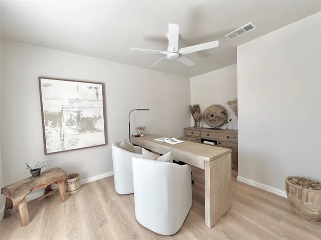 a spacious bedroom with a bed and a table chair