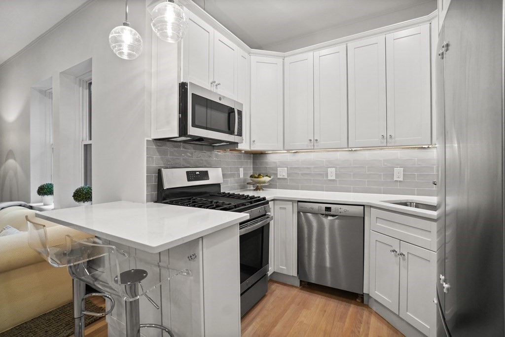 43 Anderson Street, Unit 1 Boston, MA 02114 - Photo 9 of 36 a kitchen with white cabinets and stainless steel appliances