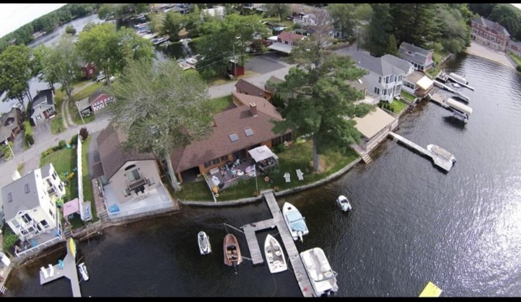 an aerial view of a house with a yard potted plants and large trees