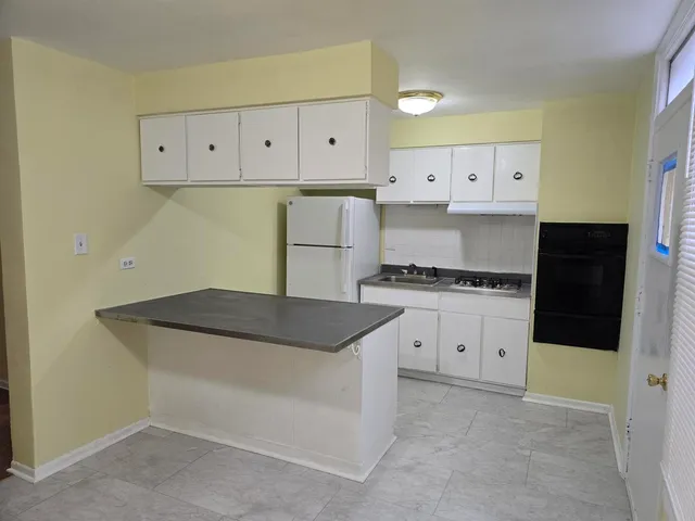 a kitchen with granite countertop white cabinets and white appliances