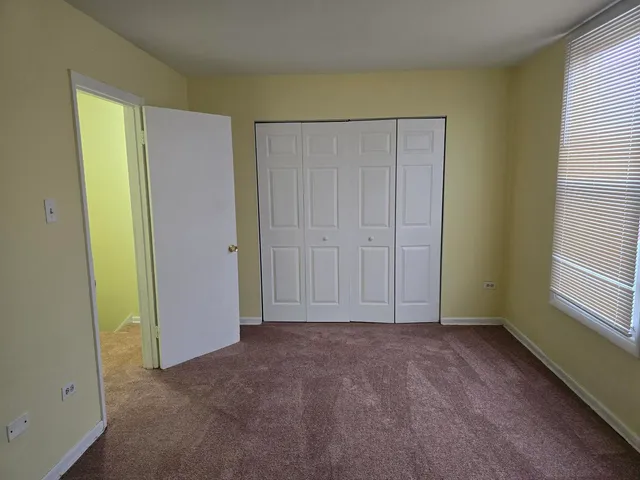 an empty room with closet and a window