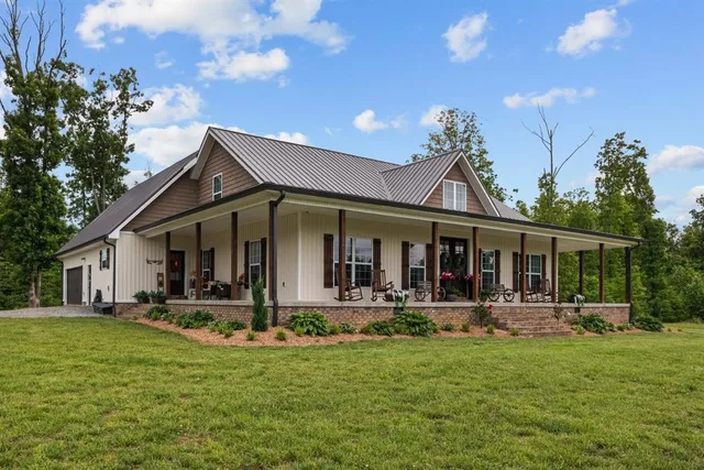 a view of a patio with a table chairs potted plants and a big yard