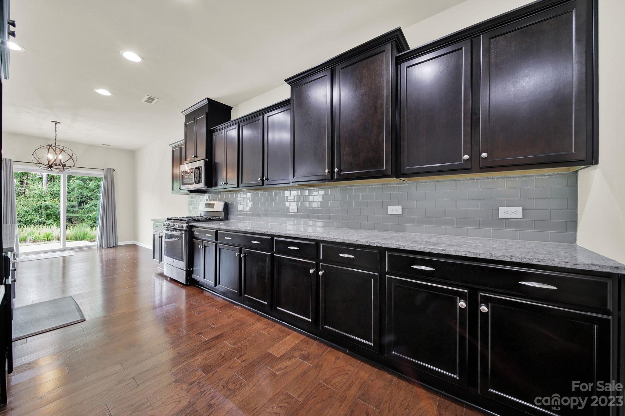 241 Butterfly Place Tega Cay, SC 29708 - Photo 16 of 42 a kitchen with stainless steel appliances granite countertop wooden cabinets and a sink