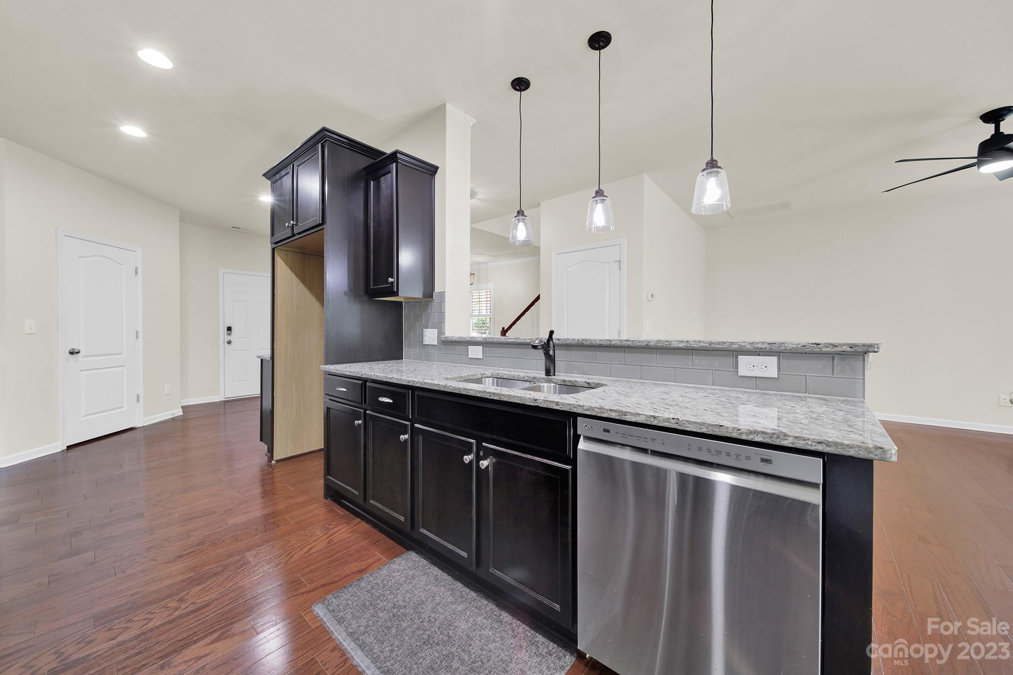 241 Butterfly Place Tega Cay, SC 29708 - Photo 17 of 42 a kitchen with stainless steel appliances granite countertop a sink a island a refrigerator and wooden floor