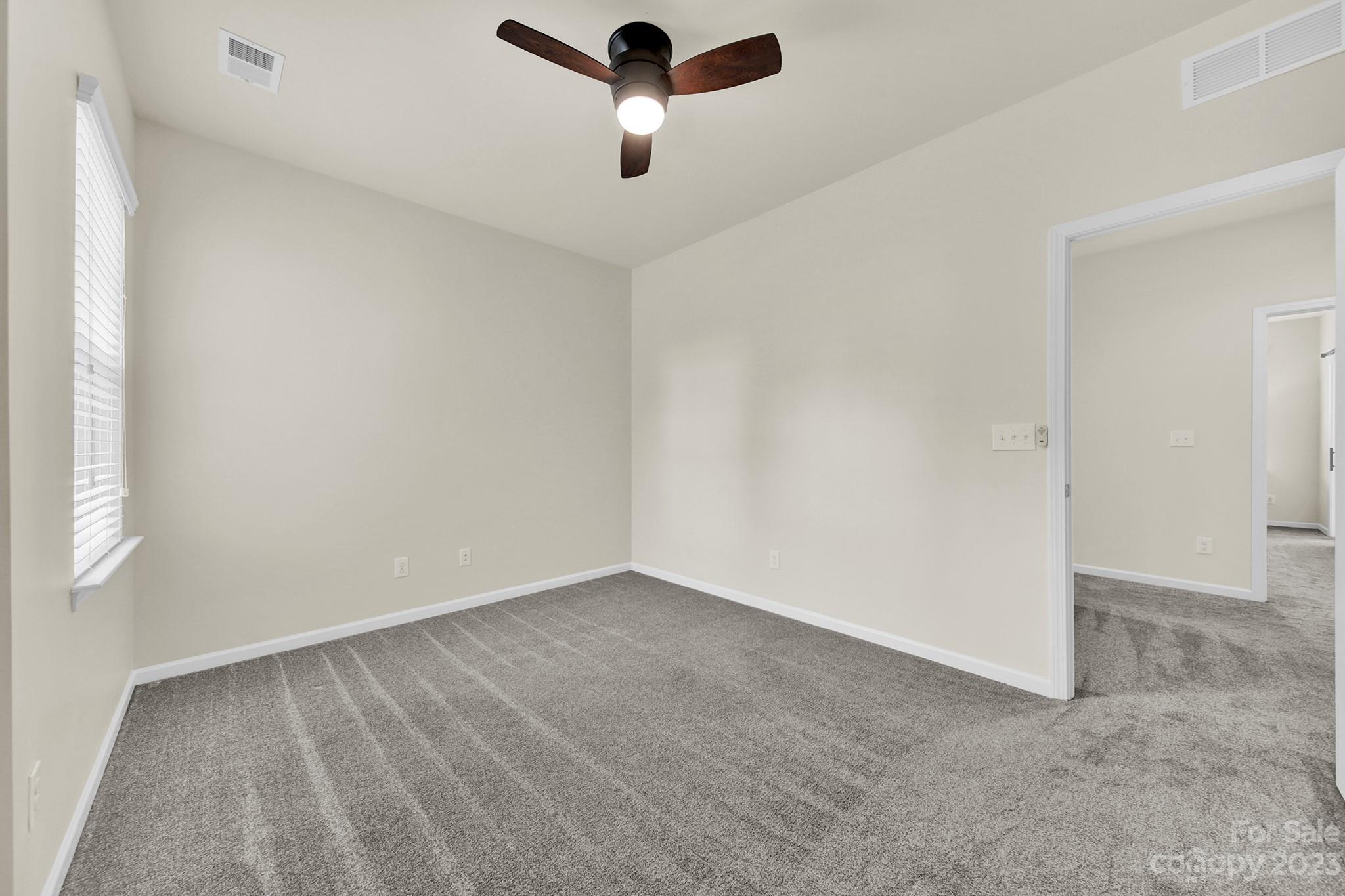241 Butterfly Place Tega Cay, SC 29708 - Photo 24 of 42 an empty room with a window and a ceiling fan