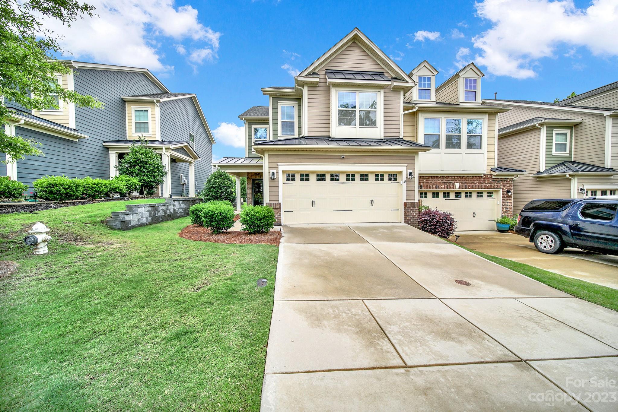 241 Butterfly Place Tega Cay, SC 29708 - Photo 3 of 42 a front view of a house with a yard and garage