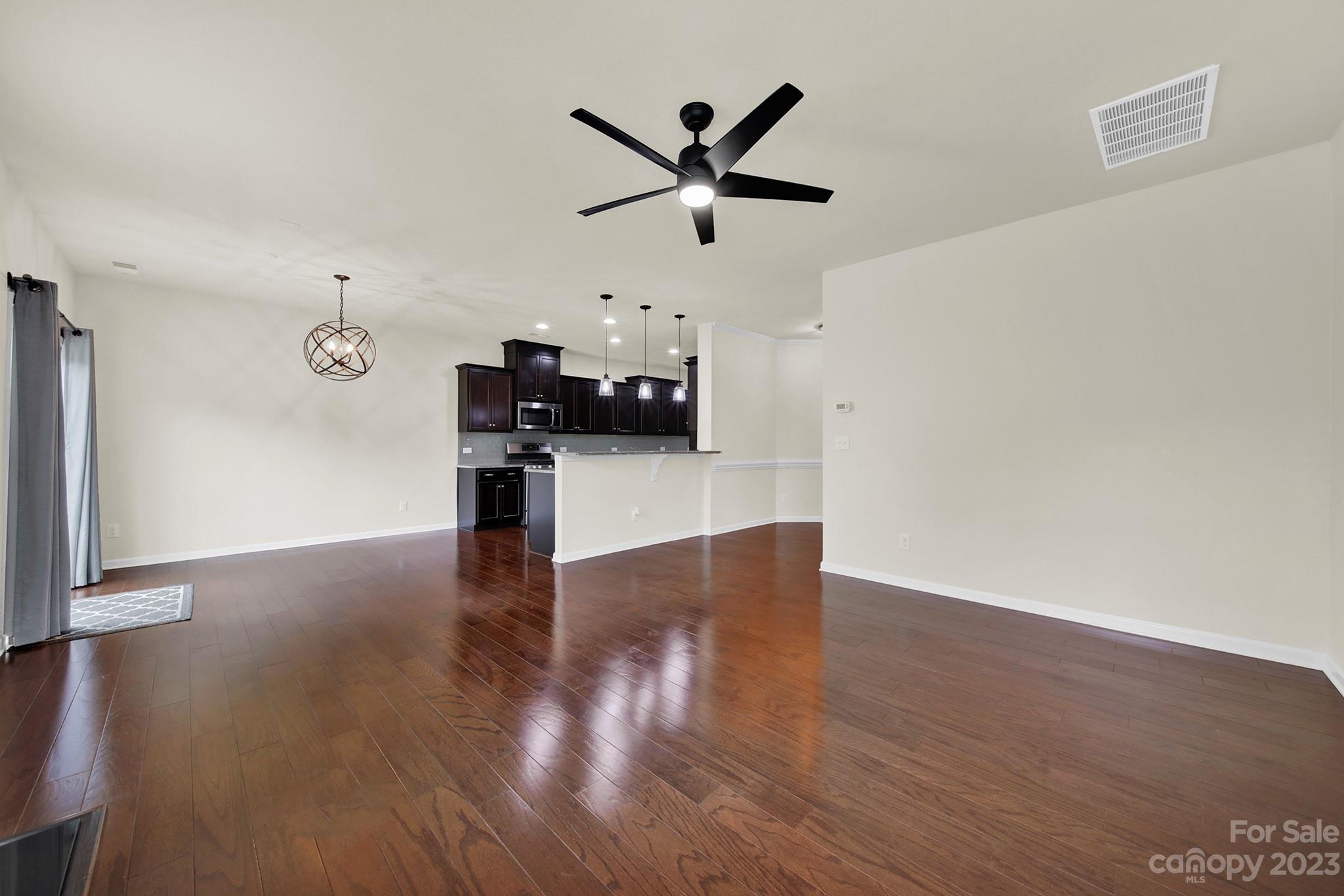 241 Butterfly Place Tega Cay, SC 29708 - Photo 9 of 42 a an empty room with wooden floor and a ceiling fan