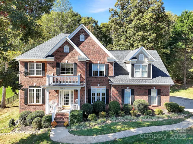 a front view of a house with a yard and potted plants