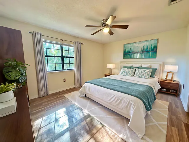 a view of empty room with wooden floor and fan